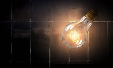 Tuğla yüzeyinde ampul. Karışık teknik