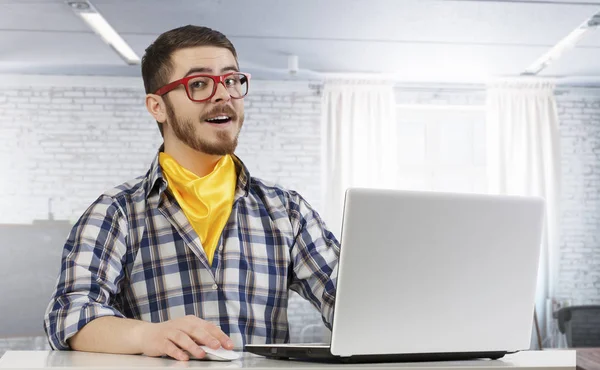Hipster guy användning laptop. Mixed media — Stockfoto