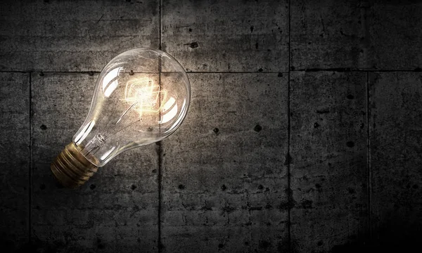 Light bulb on brick surface . Mixed media — Stock Photo, Image