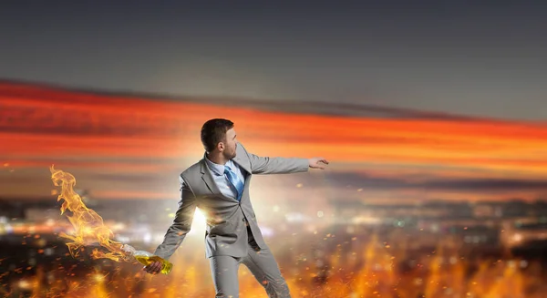 Businessman throwing petrol bomb . Mixed media — Stock Photo, Image