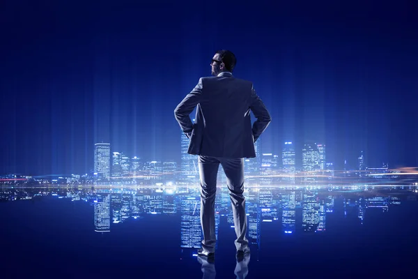 Businessman thinking and looking at night city . Mixed media — Stock Photo, Image