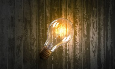 Ahşap yüzey üzerinde ampul. Karışık teknik