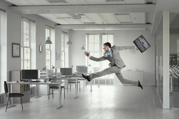 Jumping businessman in office. Mixed media . Mixed media