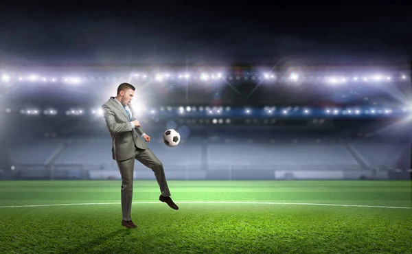 Affärsman som spelar fotboll. Mixed media — Stockfoto