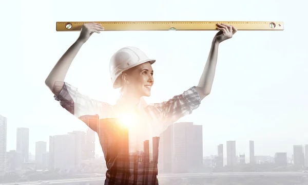 Builder woman taking measures . Mixed media — Stock Photo, Image