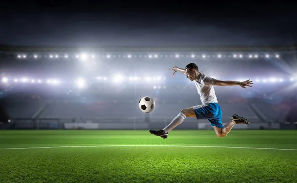 Soccer player kicking ball . Mixed media — Stock Photo, Image