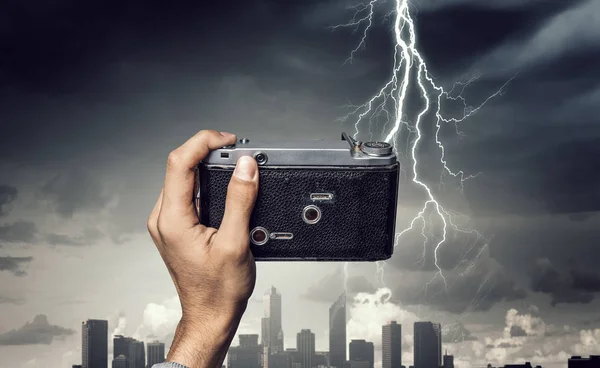 Man taking photo with vintage camera . Mixed media — Stock Photo, Image