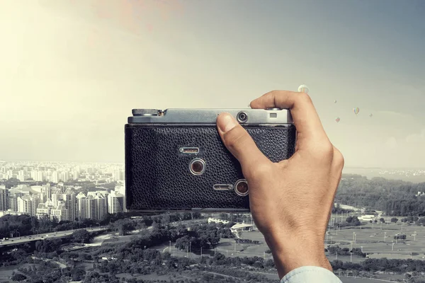 Man with camera in hands . Mixed media — Stock Photo, Image