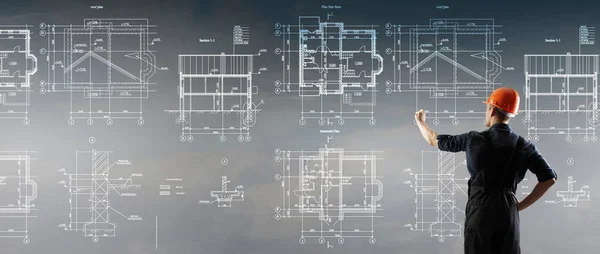 Строитель рисует проект. Смешанные СМИ. Смешанные медиа — стоковое фото