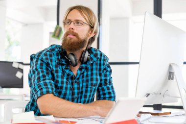 Genç adam ofiste çalışıyor.