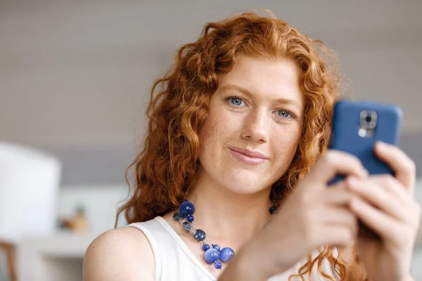 Счастливая молодая деловая женщина с улыбкой на смартфоне — стоковое фото