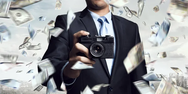 Бизнесмен фотографируется на винтажную камеру — стоковое фото