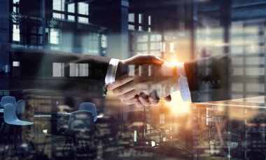 Anlaşma sembolü olarak tokalaşırken ortakları