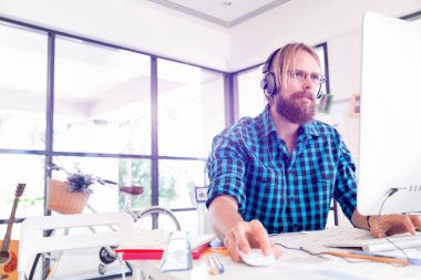 Genç adam ofiste çalışıyor.