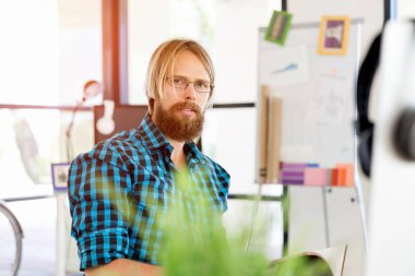 Genç adam ofiste çalışıyor.