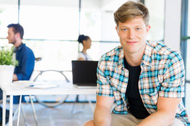 Genç adam ofiste çalışıyor.