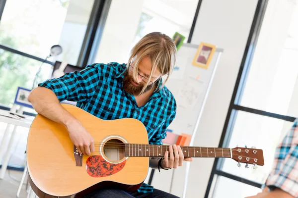 Homem tocando guitarra no escritório — Fotografia de Stock