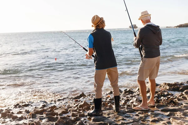 Ανώτερος άνδρας ψαρεύει με τον εγγονό του — Φωτογραφία Αρχείου