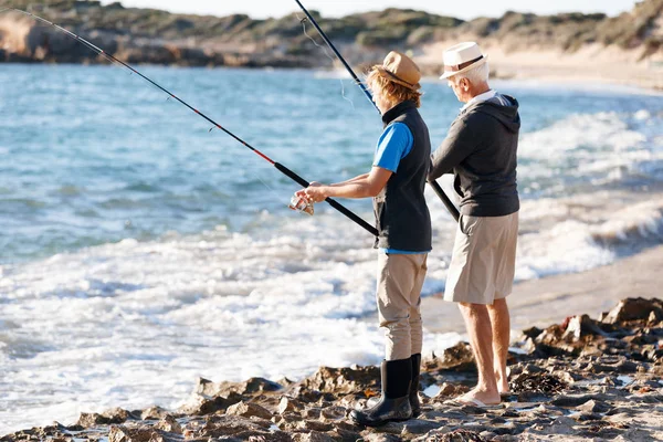 Senior man fiskar med sitt barnbarn — Stockfoto