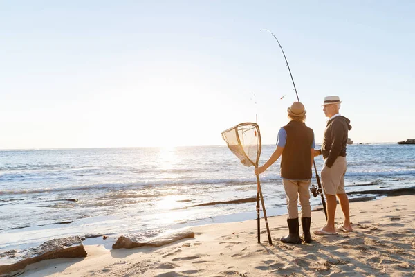 Hombre mayor pescando con su nieto — Foto de Stock