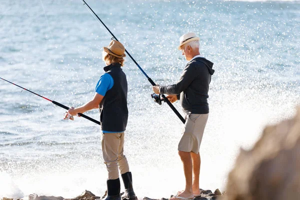 Старший чоловік риболовля зі своїм онуком — стокове фото
