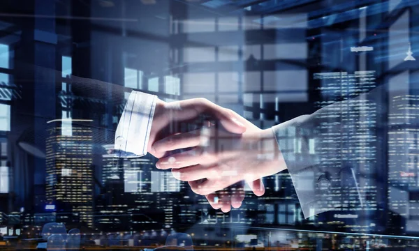 Anlaşma sembolü olarak tokalaşırken ortakları