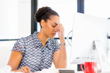 İş içinde oturan yorgun Afro-Amerikan ofis çalışanı portresi
