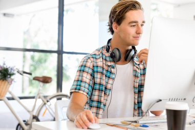 Genç adam ofiste çalışıyor.