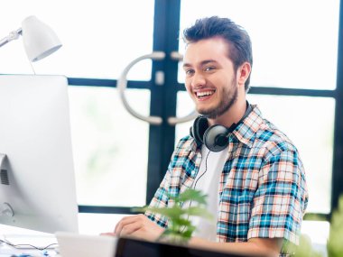 Genç adam ofiste çalışıyor.