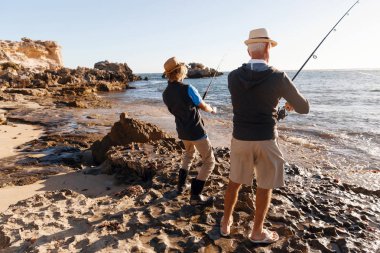 Yaşlı adam torunuyla balık tutuyor.