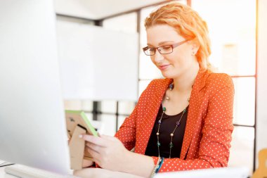 Ofiste bir fotoğraf çerçevesi tutan genç kadın