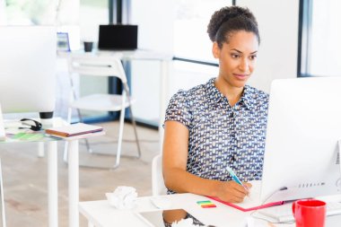 Afro-Amerikan ofis çalışanı iş içinde oturan gülümseyen portresi