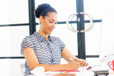 Afro-Amerikan ofis çalışanı iş içinde oturan gülümseyen portresi