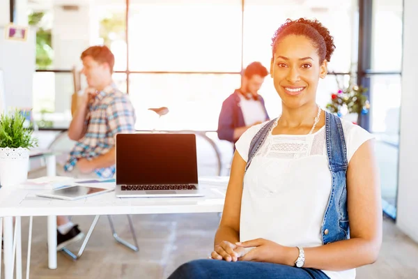 Portrait of smiling afro-american office worker in offfice with her colleagues — Stock Photo, Image