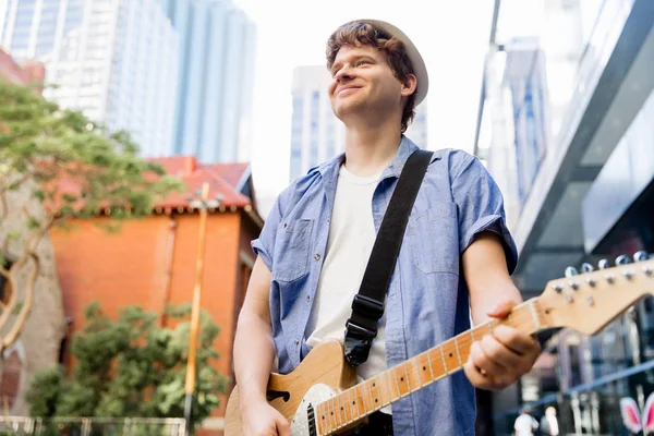 Young musician with guitar in city — Stock Photo, Image