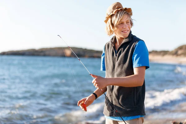 Adolescente ragazzo pesca in mare — Foto Stock