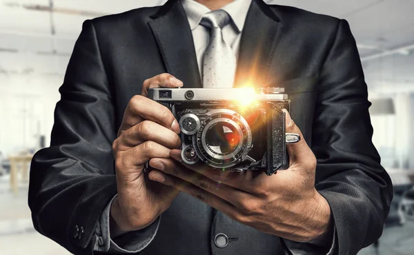 Man with camera in hands . Mixed media — Stock Photo, Image