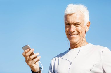 Erkek runner mobil akıllı telefonunu açık havada duran ile