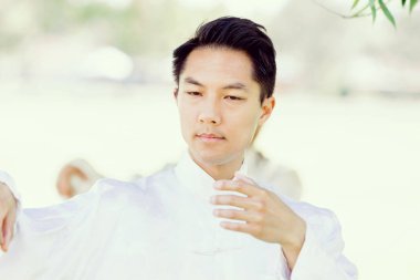 Yakışıklı adam Thai Chi yapıyor.