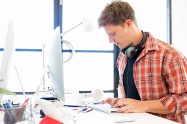 Genç adam ofiste çalışıyor.