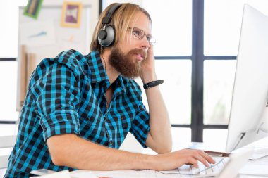 Genç adam ofiste çalışıyor.