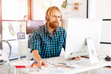 Genç adam ofiste çalışıyor.