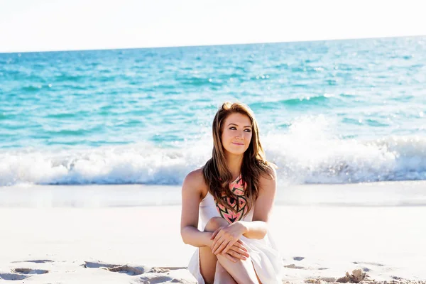 Молода жінка сидить на пляжі — стокове фото
