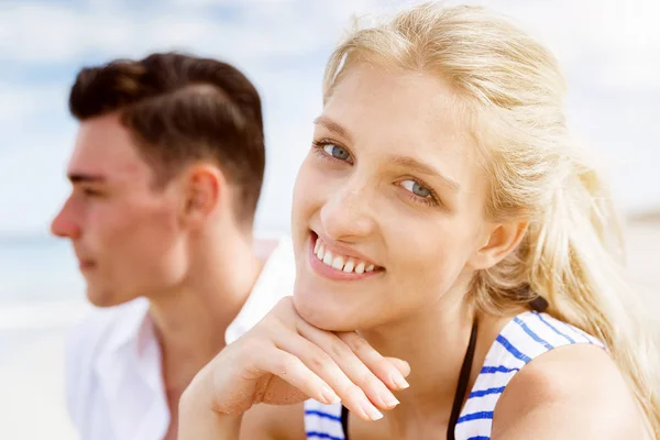 Romantische jonge paar zittend op het strand — Stockfoto