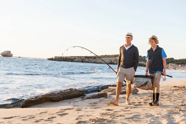 Hombre mayor pescando con su nieto — Foto de Stock