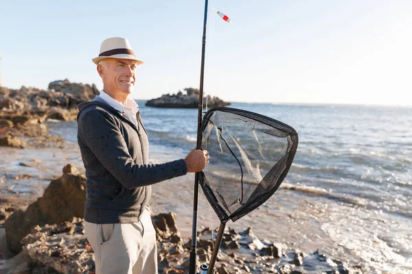 Senior mens vissen op zee zijkant — Stockfoto