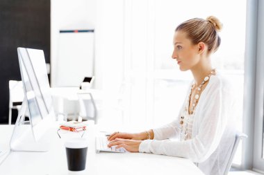 Çekici ofis çalışanı masada oturuyor.