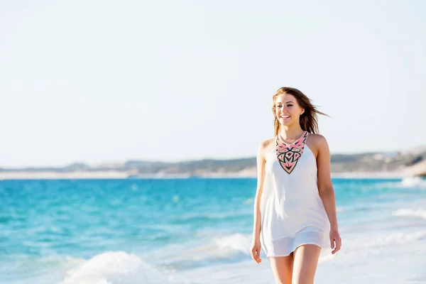 Jonge vrouw wandelen langs het strand — Stockfoto