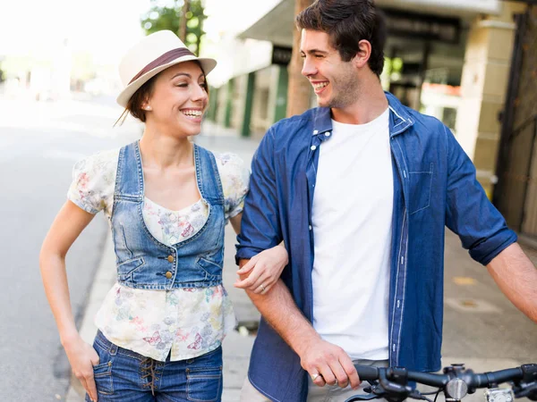 Pareja feliz en la ciudad con bicicleta —  Fotos de Stock