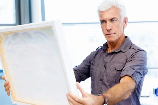 Man permanent in een galerie en overweegt illustraties — Stockfoto